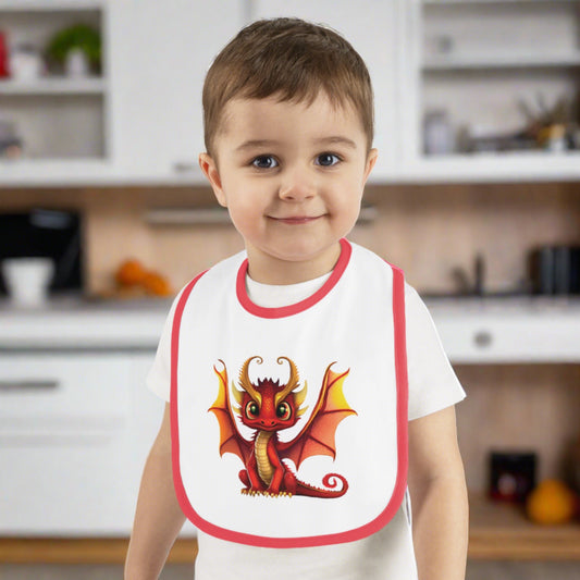 A white 100% cotton baby bib trimmed in red - with a red and gold winged horned baby Naughty dragon in the center - a large bib super cute.