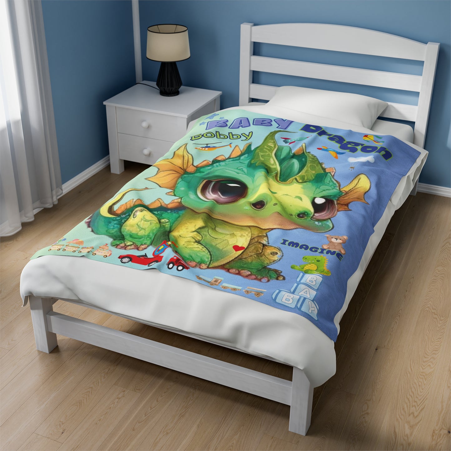 Our velveteen minky soft baby & kids blanket with a large green and gold adorable baby dragon Bobby in the center with boys toys all around, trains, trucks, dinosaurs, rocket ships and planes - the blanket color is gradient going from a beautiful light blue/green to a light blue every little boy will love