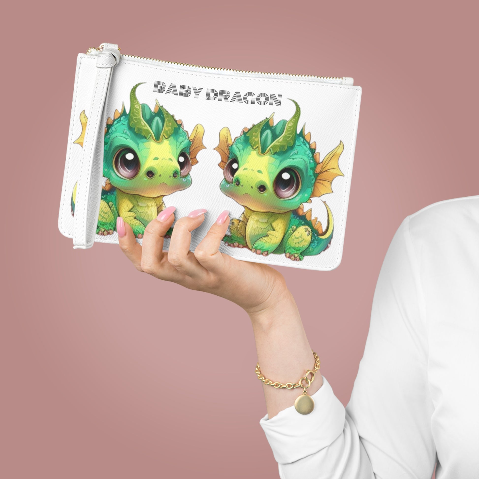 Baby Dragon is the decorative text above 2 darling baby Bobby dragons facing each other - Bobby is in greens and yellows with a little green horn popping out of his cute head - on a white vegan leather sofino patterned clutch bag with a loop white handle and gold zipper - excellent quality!